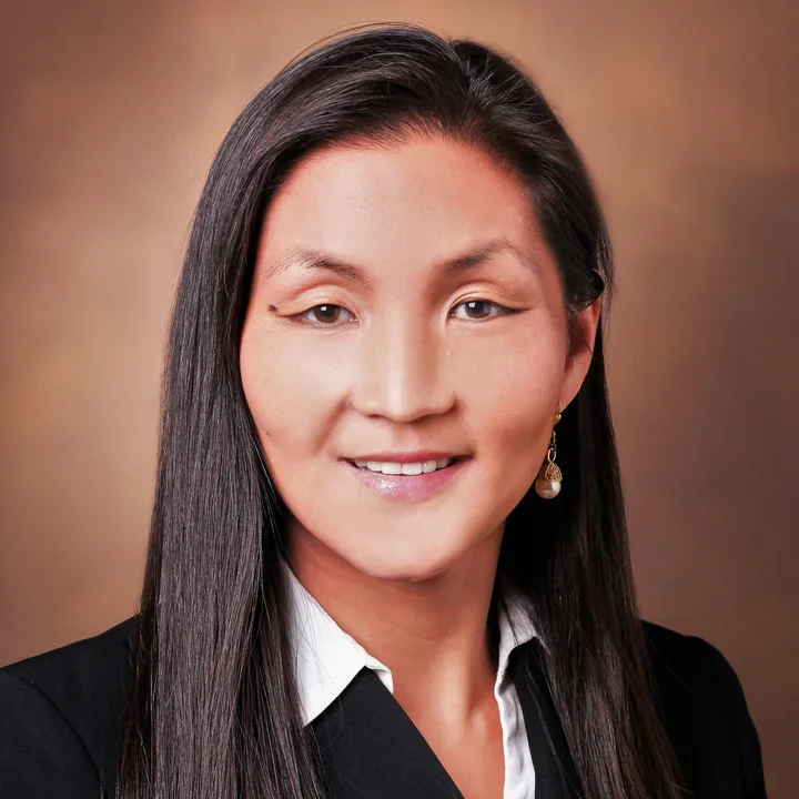 Dr. Eileen Shiuan's professional headshot in front of a brown background.